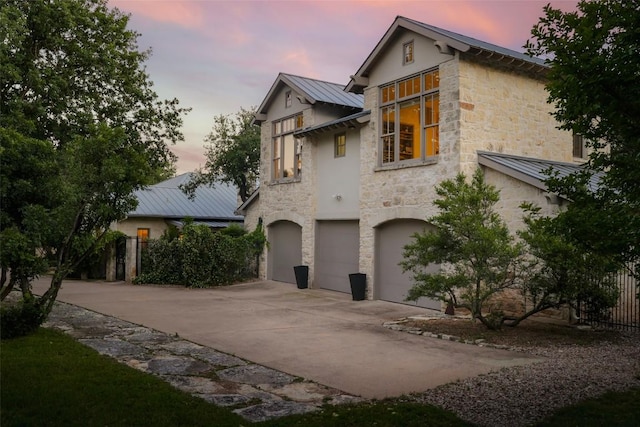 3020 Maravillas Loop, Austin, TX 78735 - view of front of home featuring a standing seam roof, an attached garage, metal roof, stone siding, and concrete driveway