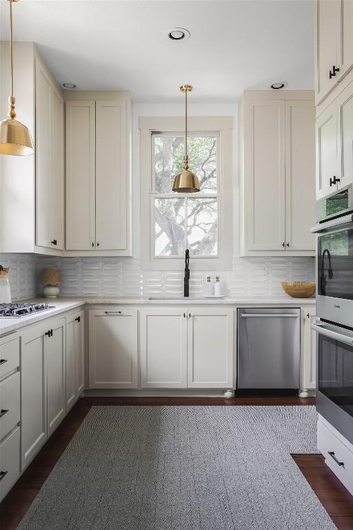 3020 Maravillas Loop, Austin, TX 78735 - kitchen featuring stainless steel appliances, a sink, decorative backsplash, light countertops, and hanging light fixtures