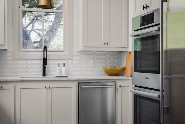 3020 Maravillas Loop, Austin, TX 78735 - kitchen featuring appliances with stainless steel finishes, tasteful backsplash, and white cabinets