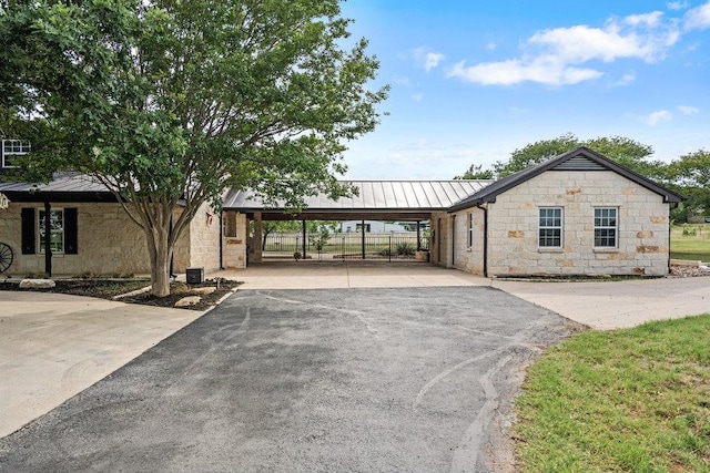 204 Bridges Ln, Buda, TX 78610 - view of front facade with a standing seam roof, stone siding, metal roof, and asphalt driveway