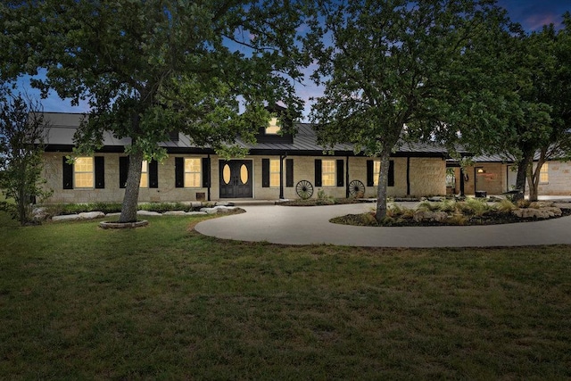 204 Bridges Ln, Buda, TX 78610 - view of front of house featuring a standing seam roof, a front lawn, curved driveway, and metal roof