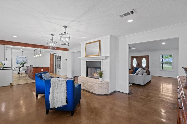 204 Bridges Ln, Buda, TX 78610 - living room featuring concrete floors, ornamental molding, a chandelier, recessed lighting, and a multi sided fireplace