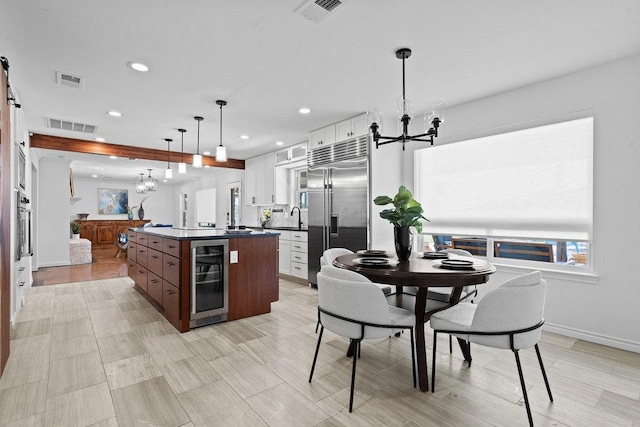 204 Bridges Ln, Buda, TX 78610 - kitchen featuring wine cooler, a chandelier, appliances with stainless steel finishes, dark countertops, and recessed lighting