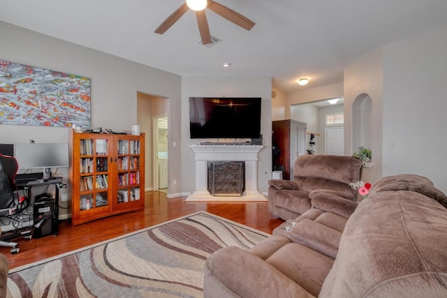 18725 Dry Lake Ln, Pflugerville, TX 78660 - living area featuring a ceiling fan, a fireplace with raised hearth, and wood finished floors