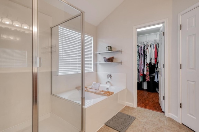18725 Dry Lake Ln, Pflugerville, TX 78660 - bathroom featuring lofted ceiling, a garden tub, a stall shower, a walk in closet, and tile patterned flooring