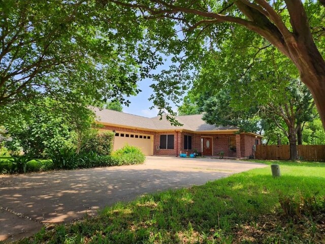 1726 Riverchase Ave, Smithville, TX 78957 - ranch-style house with an attached garage, driveway, and brick siding