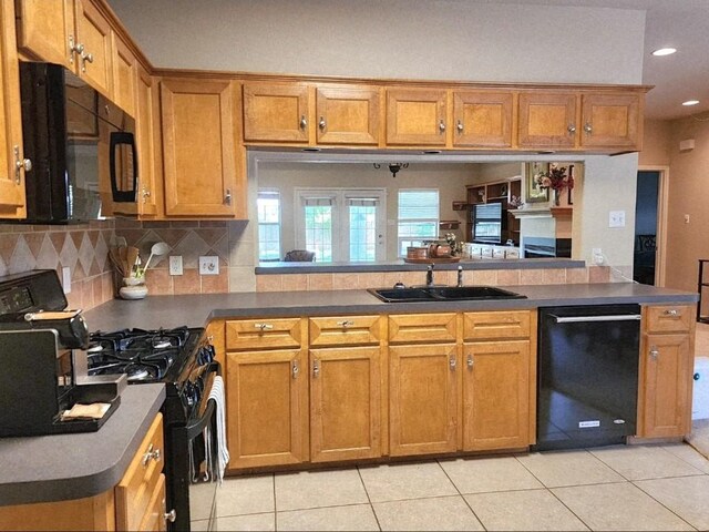 1726 Riverchase Ave, Smithville, TX 78957 - kitchen featuring black appliances, brown cabinetry, light tile patterned floors, a peninsula, and recessed lighting