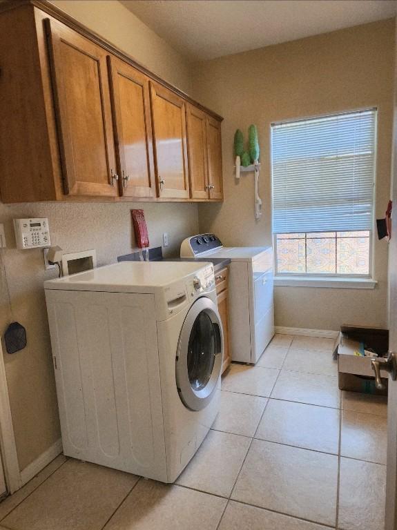 1726 Riverchase Ave, Smithville, TX 78957 - laundry room featuring cabinet space, washer and clothes dryer, light tile patterned flooring, and baseboards