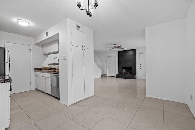 4413 Whispering Valley Dr, Austin, TX 78727 - kitchen featuring stainless steel appliances, dark countertops, light tile patterned flooring, white cabinets, and a sink