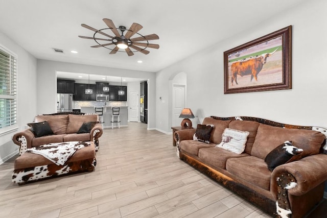 5109 Scenic Lake Dr, Georgetown, TX 78626 - living room with ceiling fan, light wood-style floors, arched walkways, baseboards, and recessed lighting
