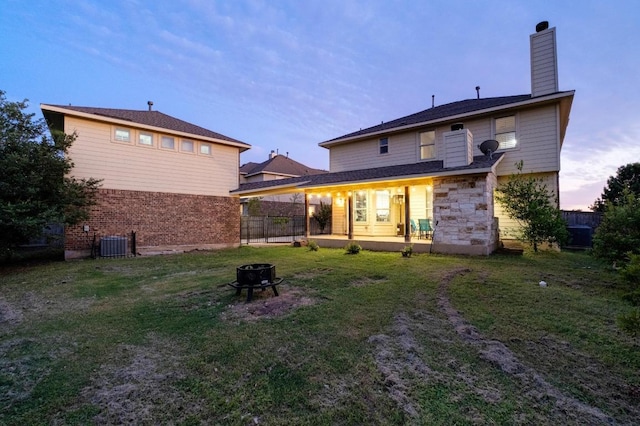 5109 Scenic Lake Dr, Georgetown, TX 78626 - back of house featuring an outdoor fire pit, a chimney, central air condition unit, and stone siding