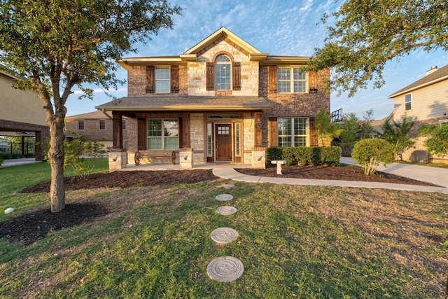 5109 Scenic Lake Dr, Georgetown, TX 78626 - traditional home featuring stone siding, a front yard, covered porch, and brick siding