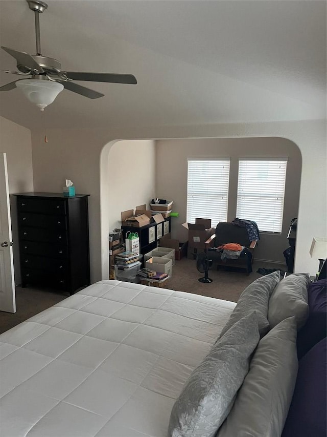 bedroom featuring carpet floors, arched walkways, and ceiling fan