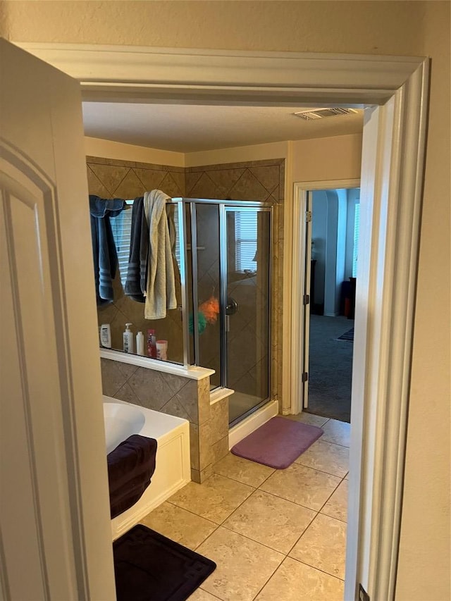 full bath with a stall shower, a bath, and tile patterned flooring