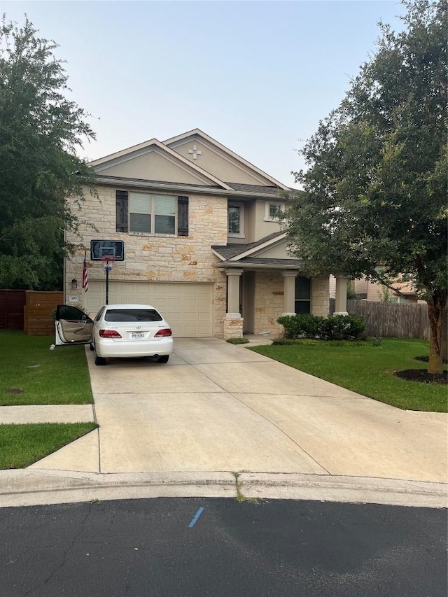 view of front of home with driveway, stone siding, an attached garage, and stucco siding