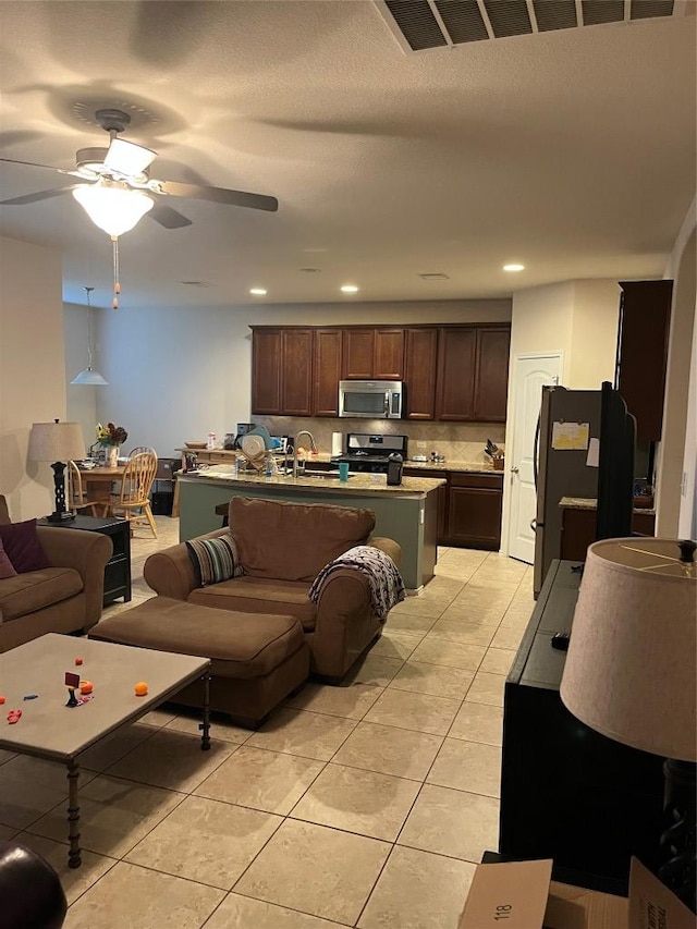 living area with a ceiling fan, light tile patterned flooring, and recessed lighting
