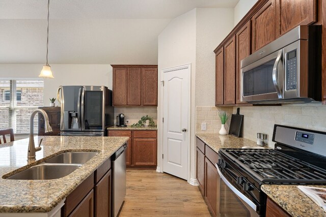 3633 Mineral Dr, Leander, TX 78641 - kitchen featuring appliances with stainless steel finishes, a sink, light wood-type flooring, decorative backsplash, and lofted ceiling