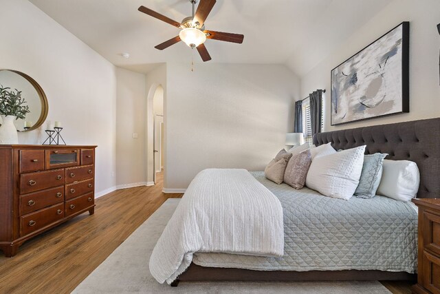 3633 Mineral Dr, Leander, TX 78641 - bedroom featuring vaulted ceiling, dark wood-style flooring, arched walkways, baseboards, and a ceiling fan
