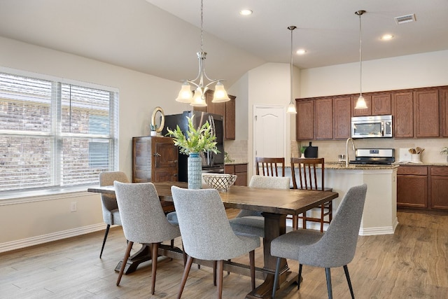3633 Mineral Dr, Leander, TX 78641 - dining area with healthy amount of natural light, light wood finished floors, a chandelier, recessed lighting, and high vaulted ceiling