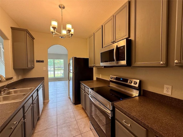 2009 Meadow View Dr, San Marcos, TX 78666 - kitchen with stainless steel appliances, a sink, arched walkways, dark countertops, and light tile patterned floors
