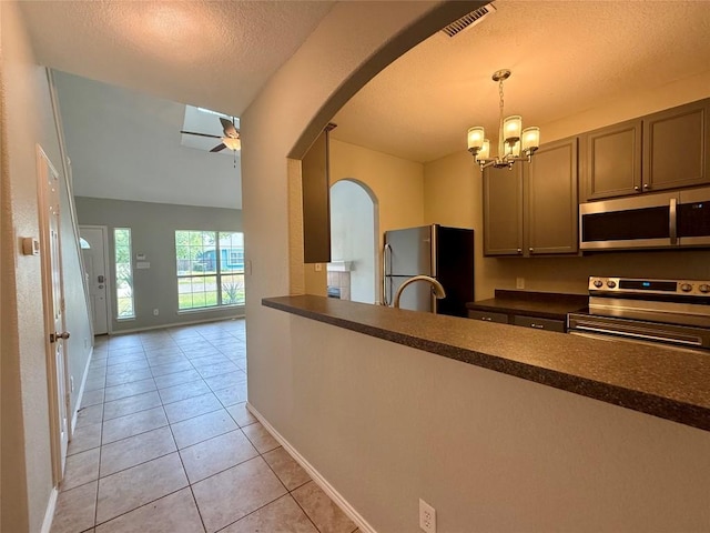 2009 Meadow View Dr, San Marcos, TX 78666 - kitchen with appliances with stainless steel finishes, arched walkways, dark countertops, light tile patterned flooring, and ceiling fan