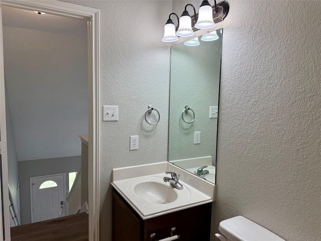 2009 Meadow View Dr, San Marcos, TX 78666 - bathroom featuring toilet, vanity, a chandelier, and a textured wall