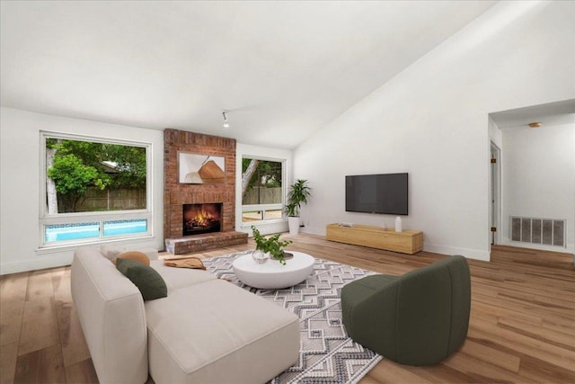 4831 Trail Crest Cir, Austin, TX 78735 - living room with wood finished floors, plenty of natural light, a fireplace, baseboards, and high vaulted ceiling