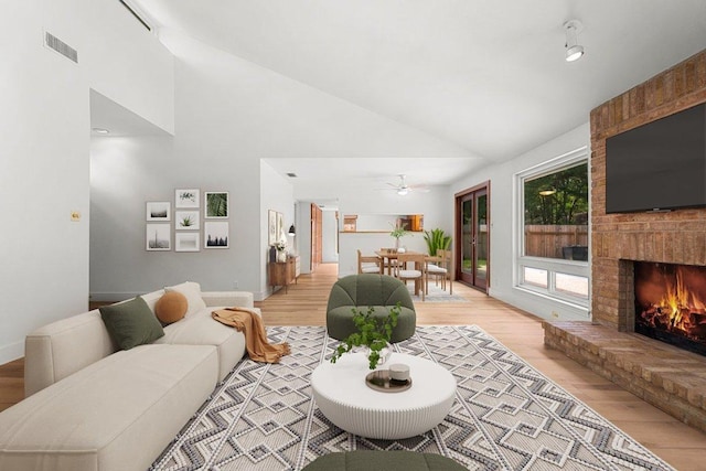 4831 Trail Crest Cir, Austin, TX 78735 - living area featuring light wood-style flooring, high vaulted ceiling, a fireplace, a ceiling fan, and baseboards