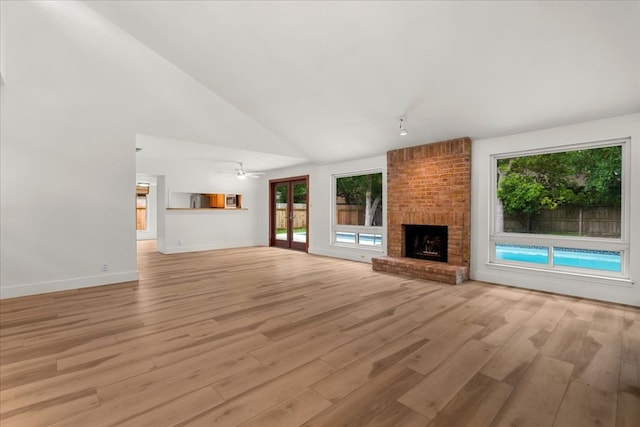 4831 Trail Crest Cir, Austin, TX 78735 - unfurnished living room featuring healthy amount of natural light, light wood-style floors, a fireplace, high vaulted ceiling, and baseboards