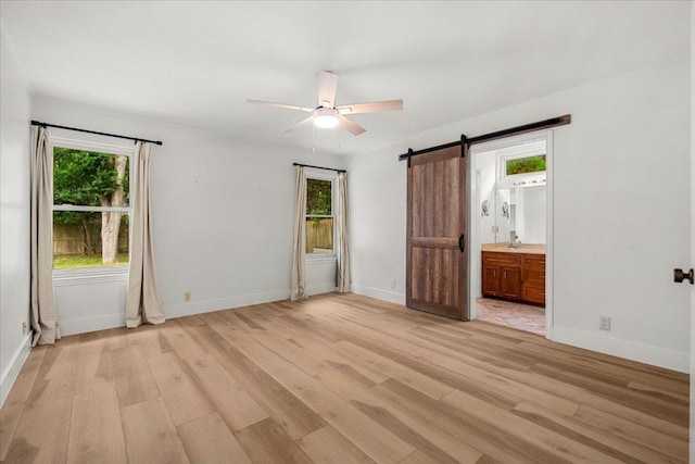 4831 Trail Crest Cir, Austin, TX 78735 - unfurnished bedroom with a barn door, multiple windows, light wood finished floors, baseboards, and ornamental molding