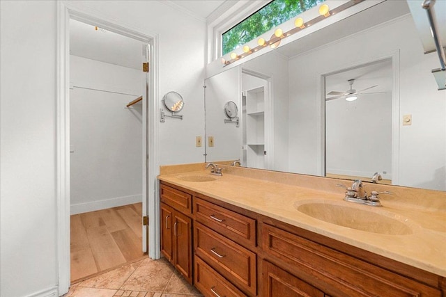 4831 Trail Crest Cir, Austin, TX 78735 - bathroom featuring double vanity, crown molding, ceiling fan, tile patterned floors, and a walk in closet