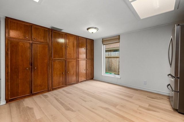 4831 Trail Crest Cir, Austin, TX 78735 - unfurnished bedroom featuring freestanding refrigerator, light wood-type flooring, and baseboards