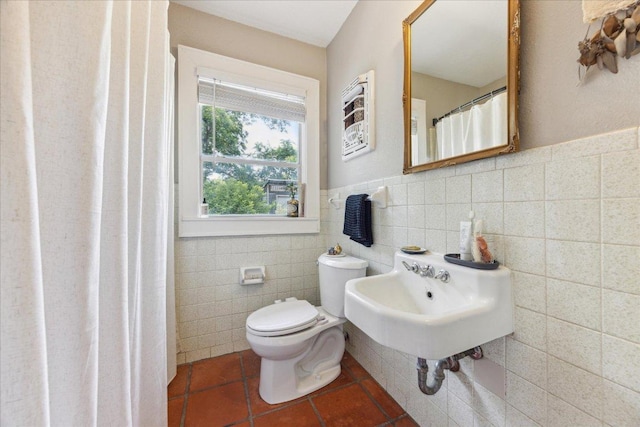 3409 Kay St, Austin, TX 78702 - bathroom featuring tile walls, toilet, tile patterned flooring, a sink, and a wainscoted wall