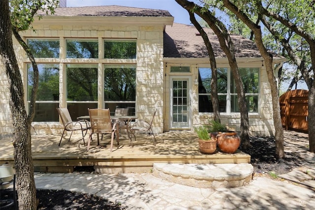 7921 Davis Mountain Pass, Austin, TX 78726 - rear view of property with a wooden deck, stone siding, outdoor dining area, and roof with shingles
