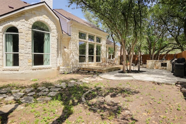 7921 Davis Mountain Pass, Austin, TX 78726 - fenced backyard featuring a patio area, a wooden deck, and exterior kitchen