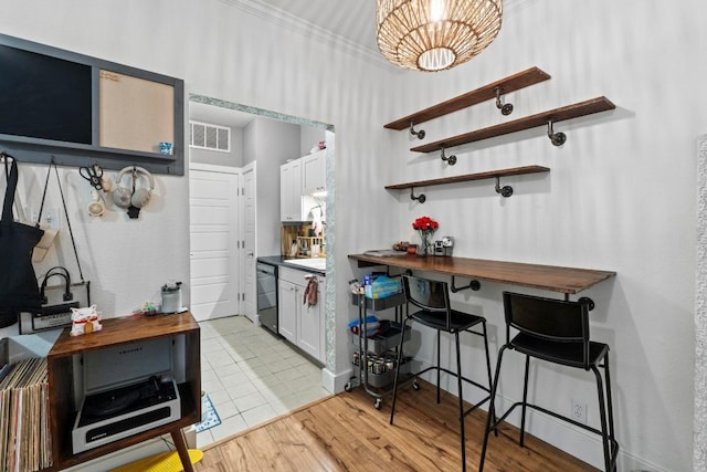 2804 Rio Grande St Unit 206, Austin, TX 78705 - kitchen featuring dishwasher, a chandelier, light wood finished floors, open shelves, and ornamental molding