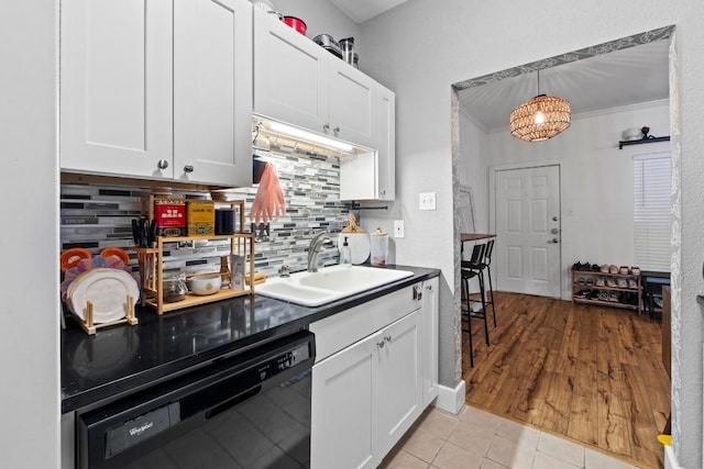 2804 Rio Grande St Unit 206, Austin, TX 78705 - kitchen featuring black dishwasher, a sink, backsplash, and white cabinetry
