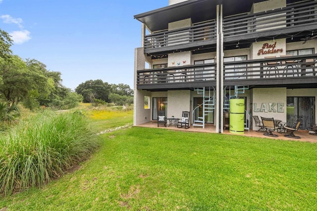 402 Lost Echo Unit 8, Horseshoe Bay, TX 78657 - back of property featuring a balcony, a lawn, water heater, and a patio