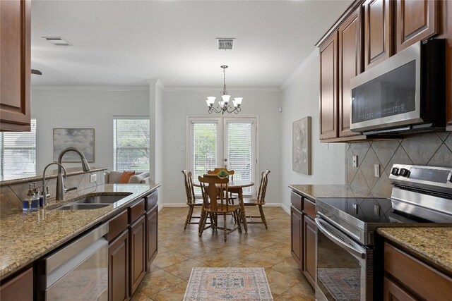 11237 Lost Maples Trl, Austin, TX 78748 - kitchen featuring appliances with stainless steel finishes, a sink, decorative backsplash, ornamental molding, and light stone counters