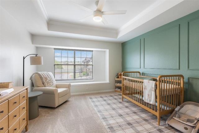 11237 Lost Maples Trl, Austin, TX 78748 - bedroom featuring crown molding, a tray ceiling, a crib, light colored carpet, and a ceiling fan