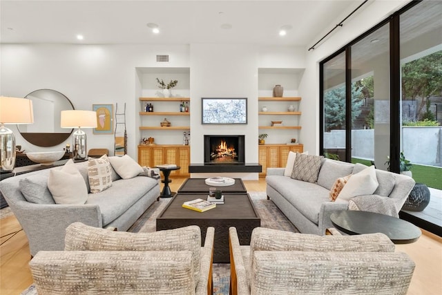 4901 Southcrest Dr, Austin, TX 78746 - living area with a lit fireplace, built in features, wood finished floors, and recessed lighting