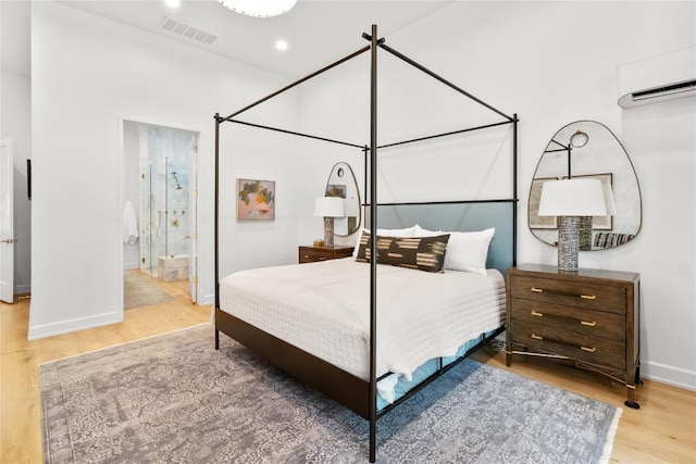 4901 Southcrest Dr, Austin, TX 78746 - bedroom featuring wood finished floors, baseboards, an AC wall unit, and ensuite bathroom