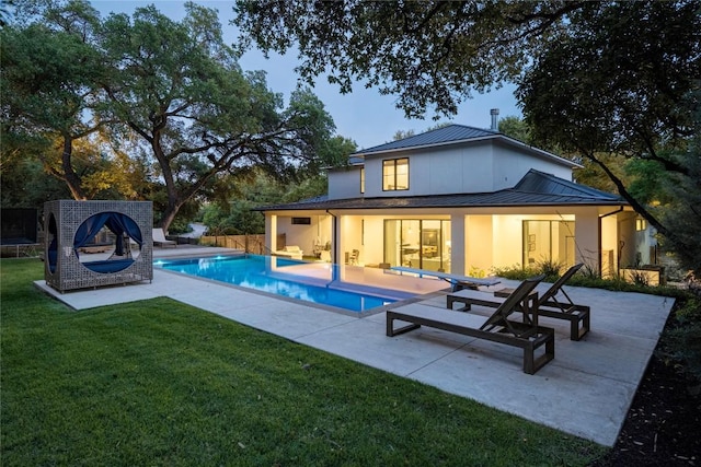 4901 Southcrest Dr, Austin, TX 78746 - back of property with a standing seam roof, metal roof, a patio, and stucco siding