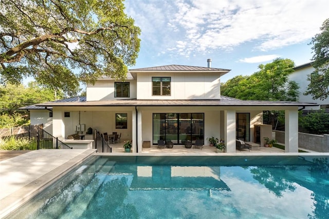 4901 Southcrest Dr, Austin, TX 78746 - rear view of property with a standing seam roof, metal roof, an outdoor pool, and stucco siding