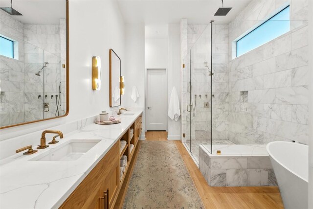 4901 Southcrest Dr, Austin, TX 78746 - bathroom featuring a shower stall, double vanity, a freestanding bath, and wood finished floors