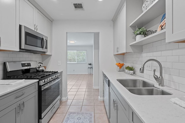 2804 Bushnell Dr, Austin, TX 78745 - kitchen with stainless steel appliances, open shelves, backsplash, light stone countertops, and light tile patterned flooring