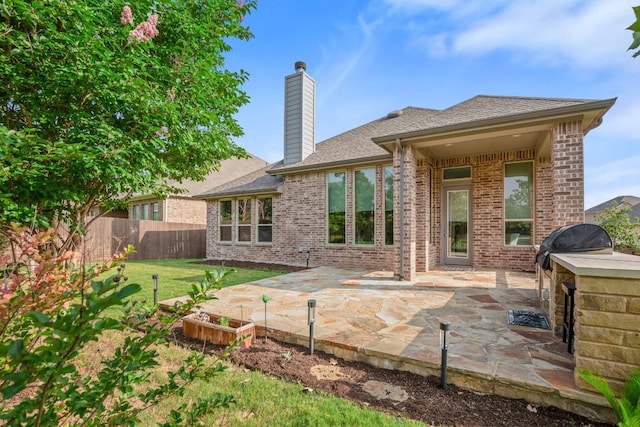 136 Medina Hills Ct, Austin, TX 78737 - rear view of property with a chimney, a patio area, brick siding, and roof with shingles