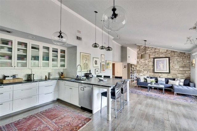 2602 Rollingwood Dr, Rollingwood, TX 78746 - kitchen with a sink, stainless steel dishwasher, open floor plan, ornamental molding, and glass insert cabinets