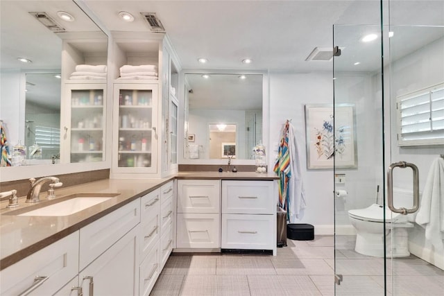 2602 Rollingwood Dr, Rollingwood, TX 78746 - bathroom featuring double vanity, recessed lighting, tile patterned floors, a stall shower, and toilet