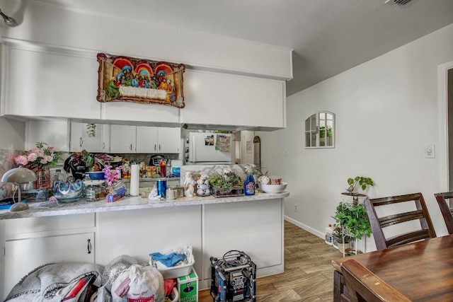 8505 Dryfield Dr, Austin, TX 78758 - kitchen with light countertops, light wood finished floors, baseboards, and white cabinets